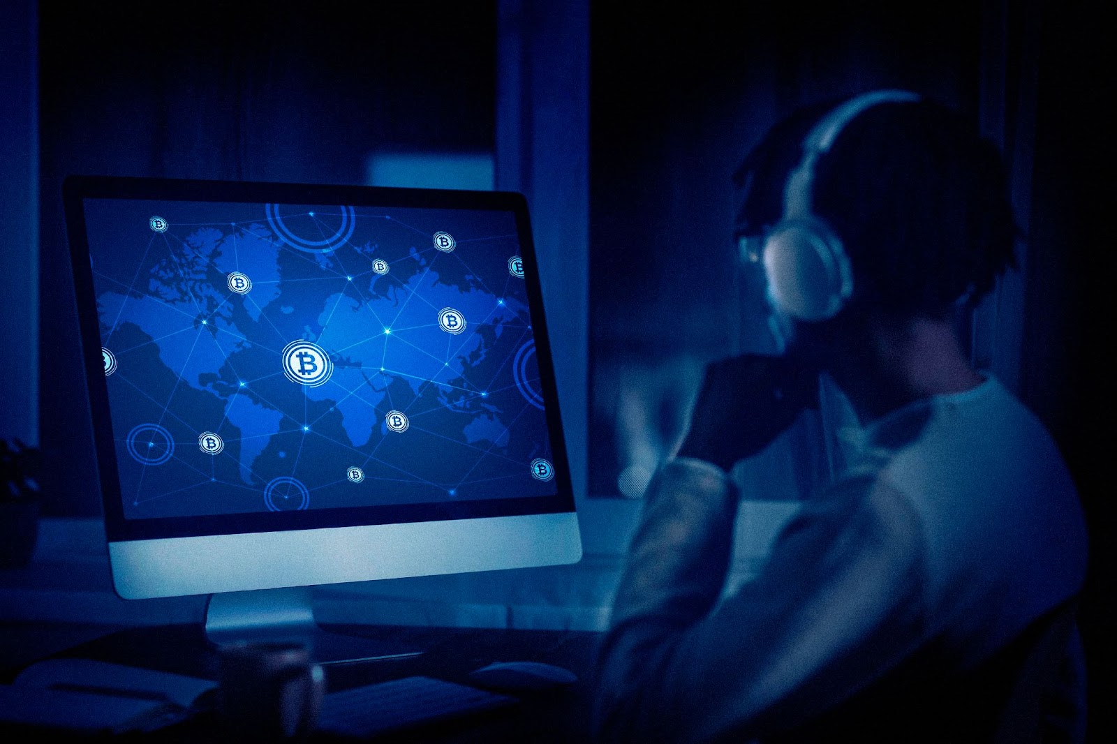 A personal looking at a screen with crypto transfers connecting over world map